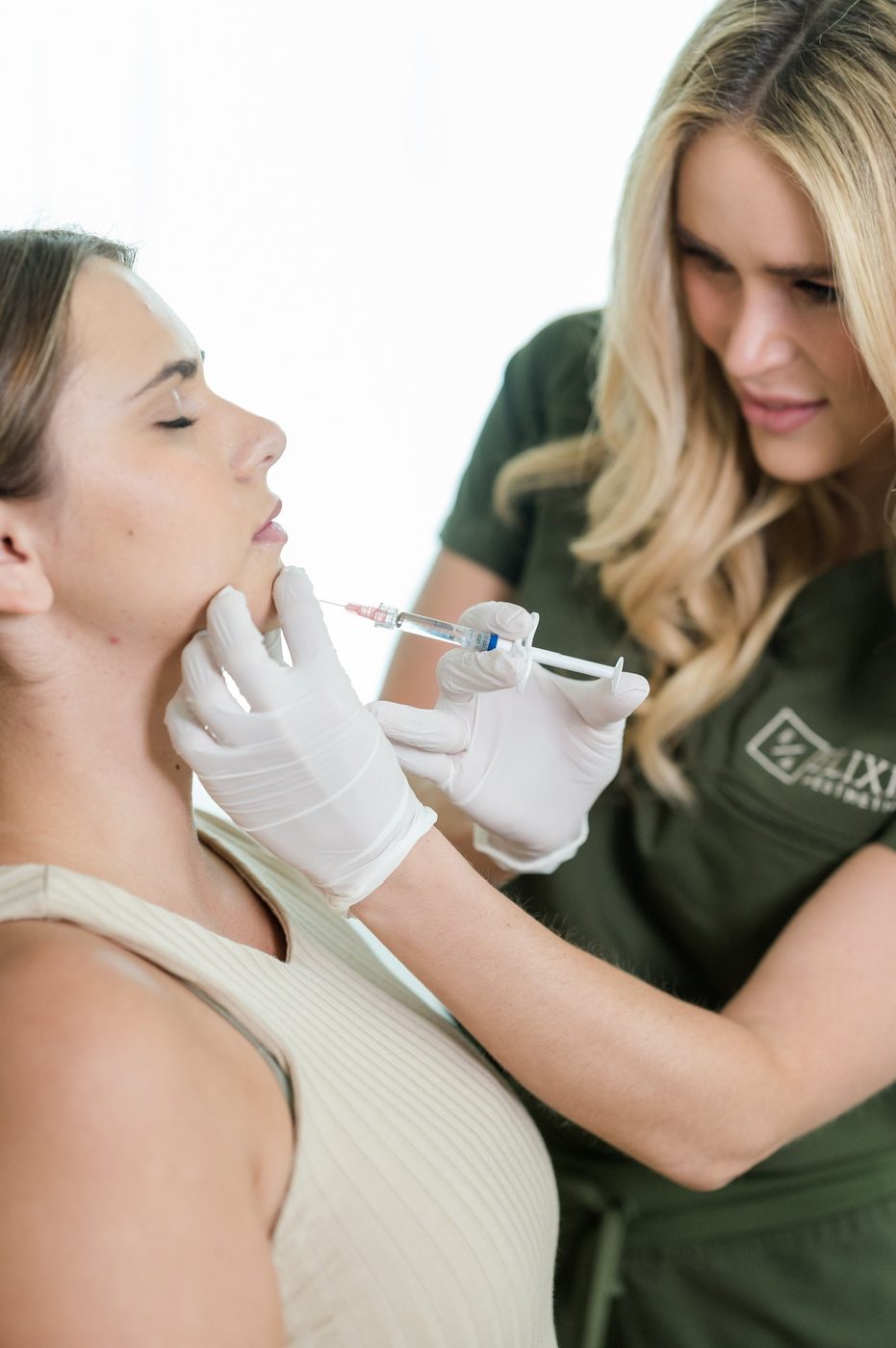 Elixir Aesthetics provider treating a patient near the chin